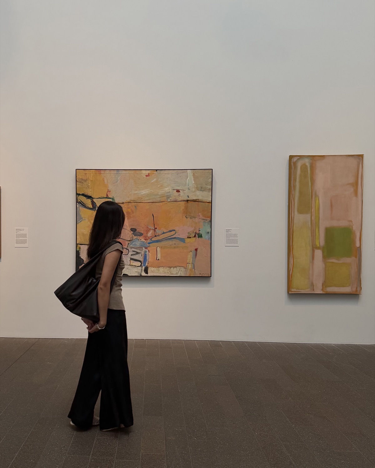 Almira looking at abstract paintings in a gallery